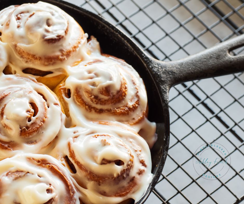 Yeast cinnamon roll recipe served in a cast iron skillet with melted cream cheese icing – cozy farmhouse breakfast fresh from the oven.