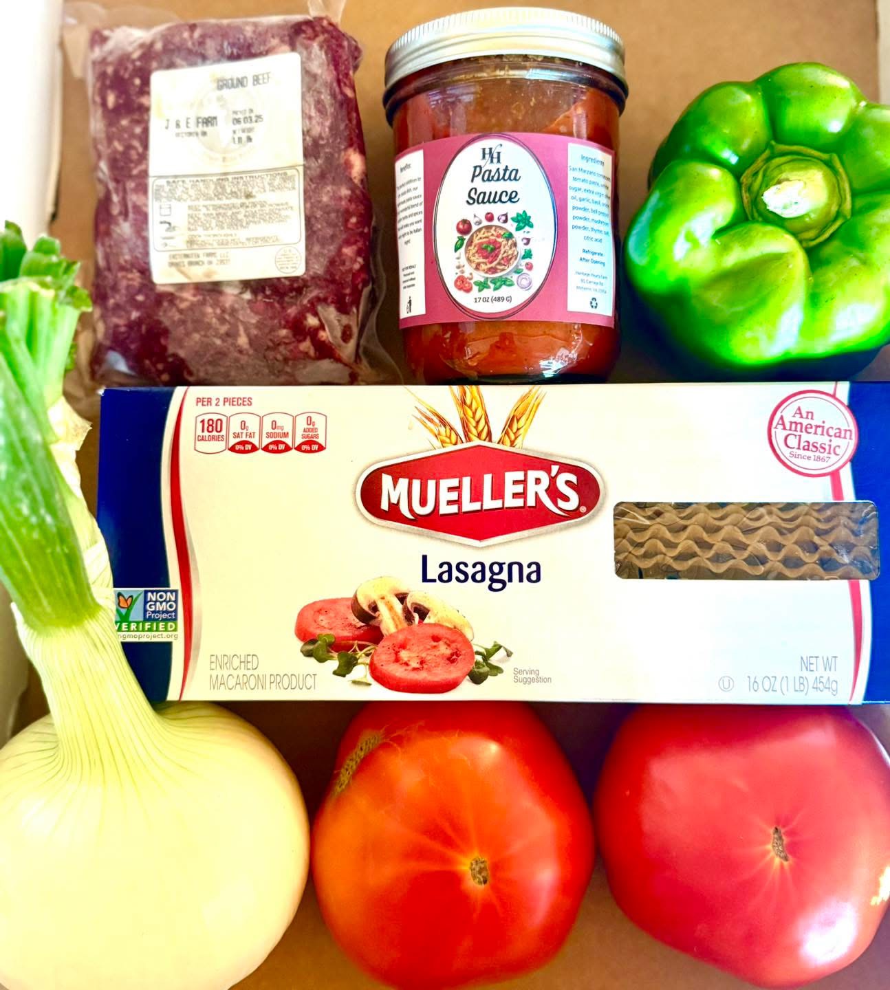 fresh lasagna ingredients from J&E Farmer’s Market including ground beef, bell pepper, onion, tomatoes, homemade pasta sauce, and box of Mueller’s lasagna noodles