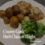 Plated creamy garlic herb chicken thighs with baby potatoes and steamed broccoli — an easy crockpot dinner.