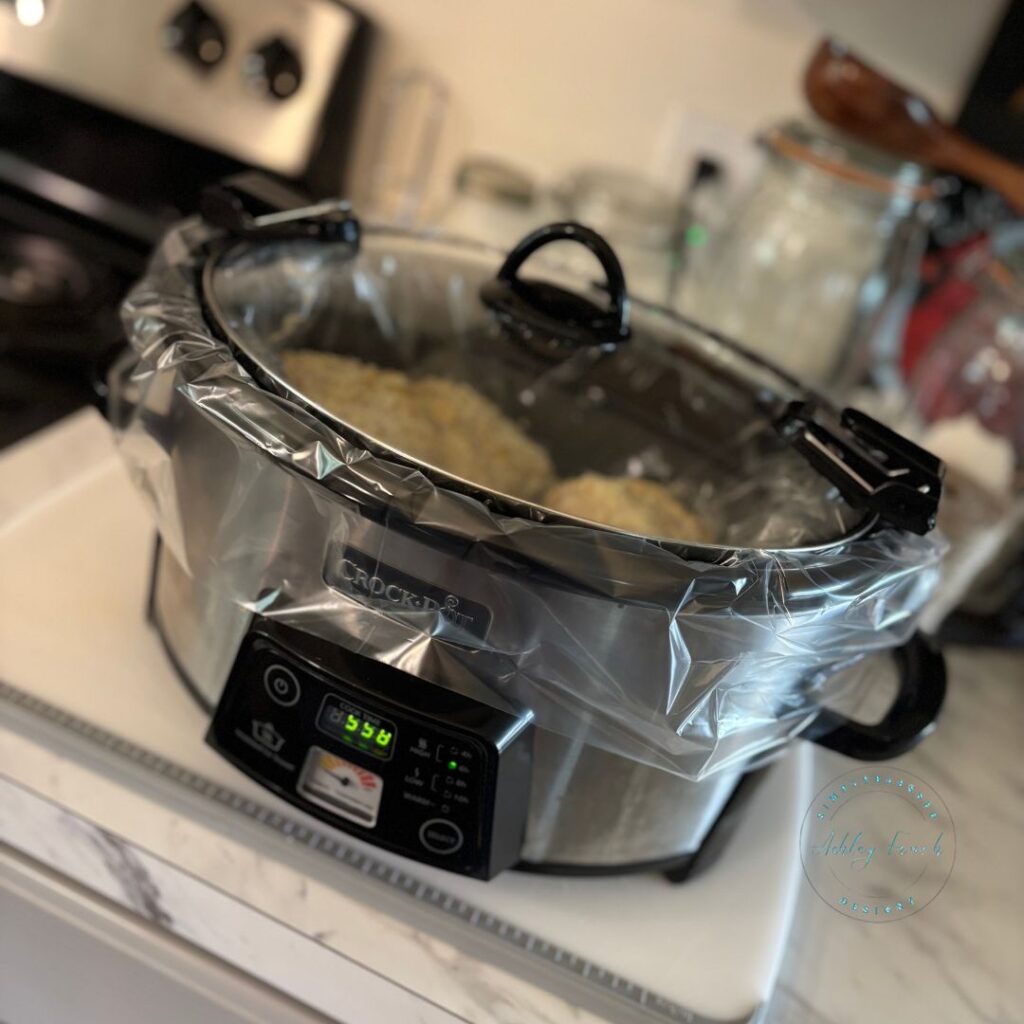 Crockpot full of cooked creamy garlic herb chicken thighs with potatoes after six hours on low.