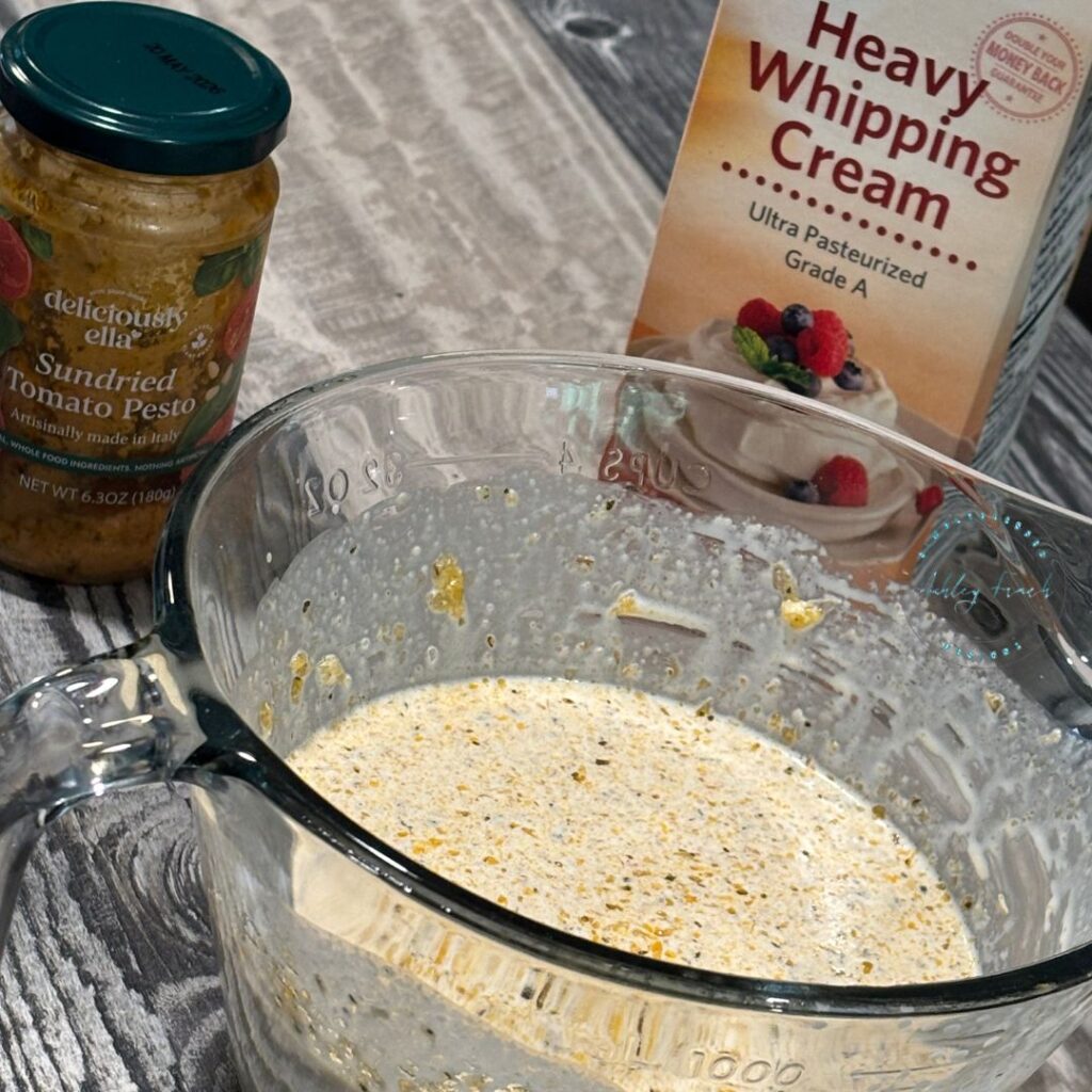 Pouring rich garlic herb cream sauce over chicken thighs and potatoes in the crockpot for a simple slow cooker dinner.